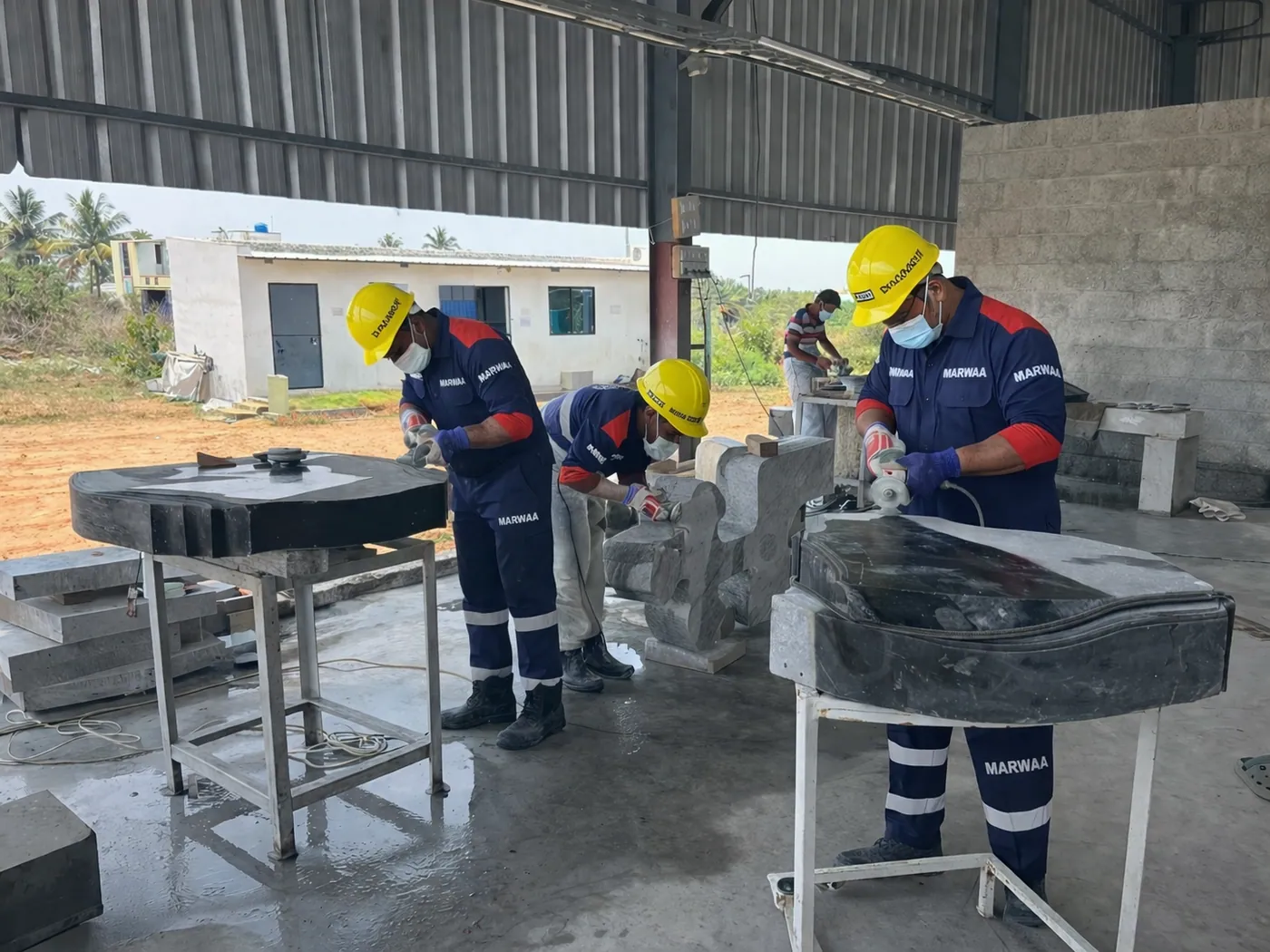 Workers hand-polishing and shaping monuments